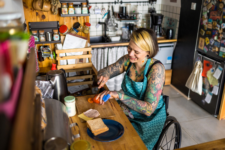 kobieta na wózku inwalidzkim przygotowuje jedzenie